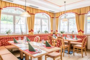restauracja z drewnianymi stołami, krzesłami i oknami w obiekcie Hotel Gell w mieście Tweng