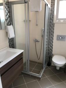 a bathroom with a shower and a toilet and a sink at Alacati Alaris Hotel in Alaçatı