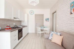 a kitchen and living room with a couch and a table at Hellen House Monopoli in Monopoli