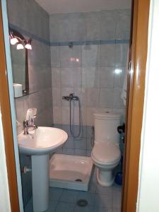 a bathroom with a sink and a toilet and a shower at Qiqi Hotel in Gjirokastër
