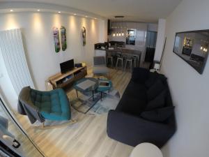 a living room with a couch and chairs and a kitchen at Sunset lovers in Lacanau-Océan