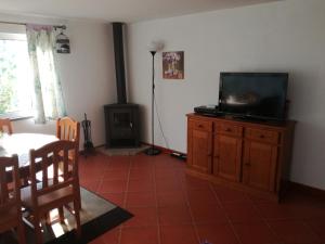 a living room with a tv on a wooden dresser at Casa Amarela - Região do Douro in Loureiro