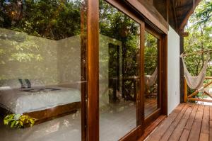 Habitación acristalada con cama en la cubierta en Jungle Chic Villa in Chemuyil, en Tulum