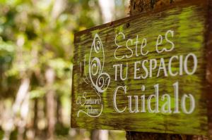 un cartel en un árbol que lee esencia a versaza guatemala en Jungle Chic Villa in Chemuyil, en Tulum