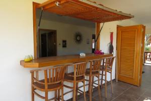 a kitchen with a bar with wooden stools at Apartemento Gosa Bunita in Willemstad