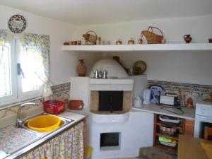 a kitchen with a sink and a counter with a stove at Casa Amarela - Região do Douro in Loureiro