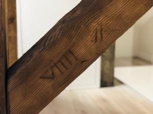 a close up of the wooden arm of a table with the word arma at Memel home old city apartment in Klaipėda