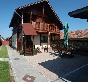 a house with a deck and a bench on a patio at Pensiunea Denis in Cârțișoara