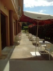 una fila de mesas y sillas con sombrilla en Hotel l'Albera en La Jonquera