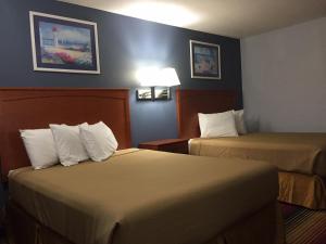 a hotel room with two beds in a room at Travelodge by Wyndham Spirit Lake/Okoboji in Spirit Lake