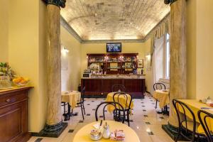 a restaurant with tables and chairs and a bar at Cambridge Hotel in Rome