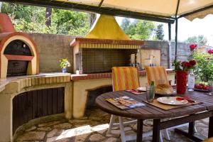 an outdoor kitchen with a table and an outdoor oven at Achilles Country House in Corfu Town +8 photos