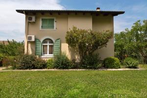 a house with a green window and a grass field at Achilles Country House in Corfu Town