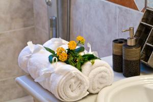 a bathroom with towels and flowers on a sink at Achilles Country House in Corfu Town