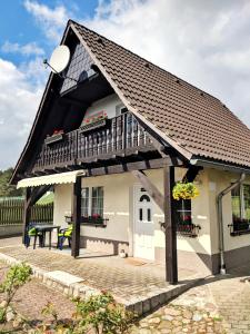 Cette petite maison dispose d'un balcon et d'une table. dans l'établissement Pension am Silberberg, à Gartz an der Oder