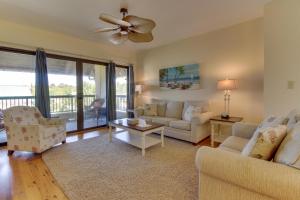 a living room with two couches and a ceiling fan at The Club at Mexico Beach in Mexico Beach