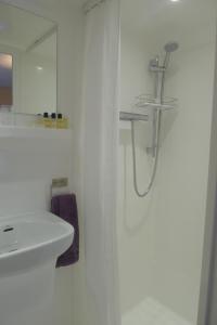 a white bathroom with a sink and a shower at Sunrise in Newhaven