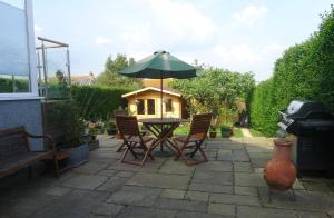 a patio with a table with a green umbrella at Sunrise in Newhaven