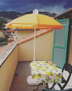einen Stuhl und einen Regenschirm auf dem Balkon in der Unterkunft La Soffitta di Maria in La Spezia