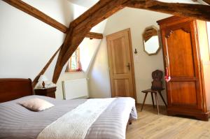 a bedroom with a bed and a wooden door at La Parenthèse in Kaysersberg