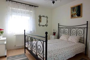 a bedroom with a black bed and a window at M&aacute;ria-lak Zalakaros in Zalakaros
