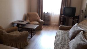 a living room with chairs and a couch and a tv at Kandelaki in Tbilisi City