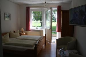 Schlafzimmer mit einem Bett und einem Fenster in der Unterkunft Pension Treenehof in Friedrichstadt