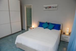 ナポリにあるCasa del Porto al Borgo Marinariのベッドルーム(青い枕の大きな白いベッド付)