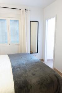 sypialnia z dużym łóżkiem i 2 oknami w obiekcie La Tierra Sur apartment Malaga Center w Maladze
