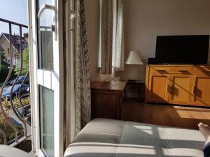 a living room with a television and a balcony at Coast house, Norfolk road,Littlehampton, Free parking driveway in Littlehampton
