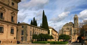 un vecchio edificio con una torre dell'orologio e una chiesa di La Casa del Alfarero - Premio Andalucia de Artesania a Úbeda