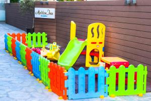a colorful wooden toy fence with a playground at Meliton Inn Hotel & Suites by the beach in Neos Marmaras
