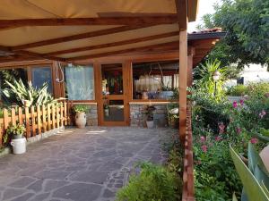 un patio con pérgola de madera y plantas en Agriturismo Macchia di Riso, en Nova Siri Marina