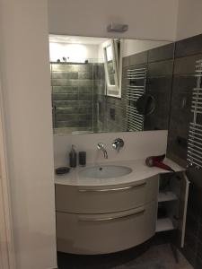 a bathroom with a sink and a mirror at AppartArbus white suite in Arbus
