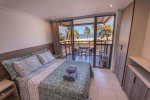 a bedroom with a bed and a view of the ocean at Luxor Cabo Branco Home Service in João Pessoa