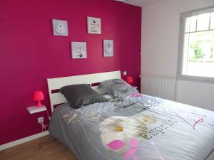 Un dormitorio con una pared púrpura y una cama en Villa du Cabestan, en Andernos-les-Bains