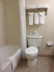 a bathroom with a toilet and a tub and towels at Gulfview Hotel - On the Beach in Clearwater Beach