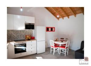 a kitchen with a table and a white refrigerator at Casa do Zé II AL in Velas