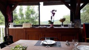 B&B En plein coeur de la forêt في Artiguelouve: غرفة طعام مع طاولة ونافذة