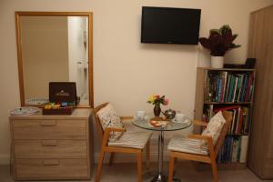 Zimmer mit einem Tisch, 2 Stühlen und einem Spiegel in der Unterkunft Sunrise in Newhaven