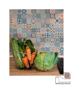 un montón de verduras en una cesta sobre una mesa en Casa do Zé II AL en Velas
