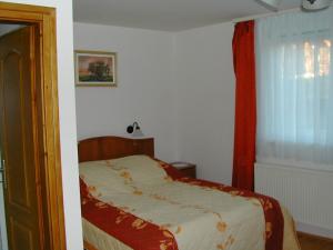 a small bedroom with a bed and a window at Panoráma Apartmanház in Sárvár