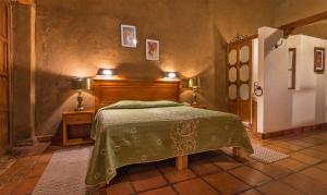 a bedroom with a bed with a green bedspread at Hotel Refugio del Angel in Pátzcuaro