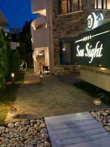 a sign in front of a building at night at Sea Sight Boutique Hotel in Porto Rafti
