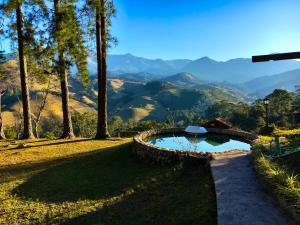 a swimming pool with a view of the mountains at Casa da Colina Chalés in Visconde De Maua