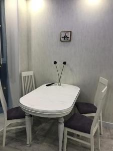 キーウにあるLuxe Apartment on Drahomanovaの白いテーブルと椅子2脚