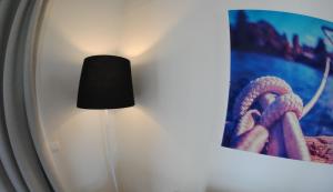 a black lamp next to a picture on a wall at TRH Tirant Playa in Fornells