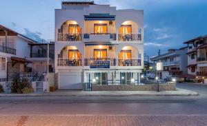a large white building with balconies on a street at House Katerina Mediterranean in Sarti