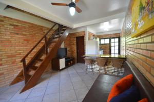 a living room with a staircase and a brick wall at Residencial Costa Mar in Bombinhas