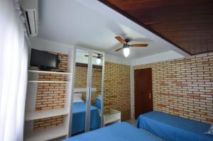 a bedroom with a blue bed and a ceiling fan at Residencial Costa Mar in Bombinhas